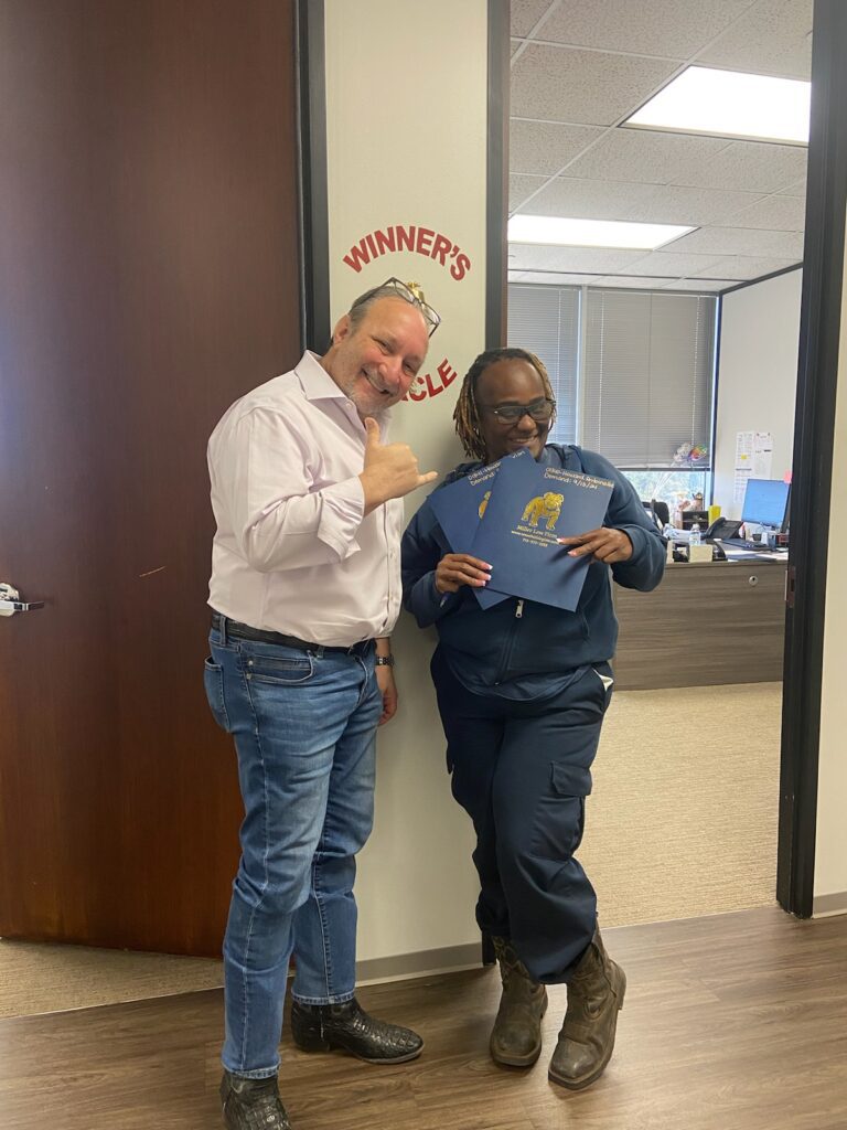 Happy client ringing the Winner’s Circle bell with attorney Adam Miller at The Miller Law Firm – The Texas Bulldog in Houston.