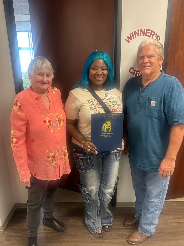 Client holding Miller Law Firm folder after settlement win in Houston.