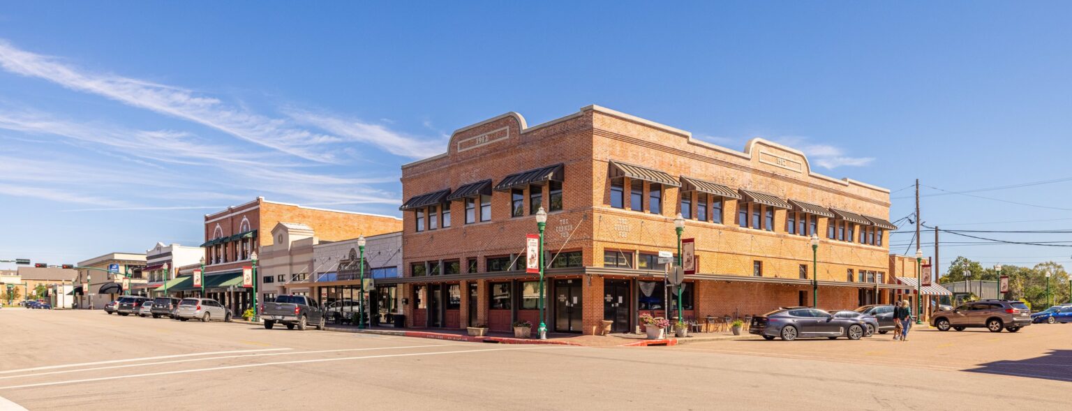 Historic brick storefronts on a downtown street in Conroe, Texas, on a sunny day