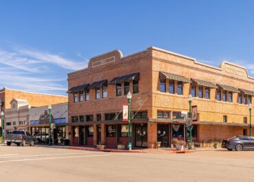 Historic brick storefronts on a downtown street in Conroe, Texas, on a sunny day