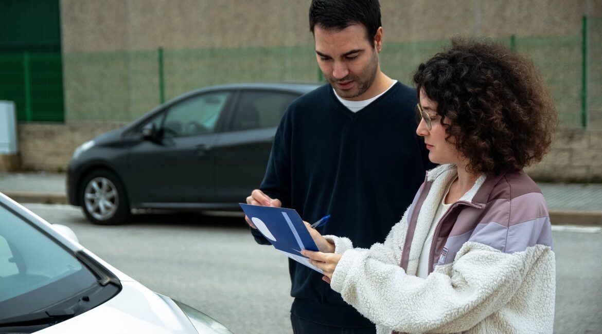 Two drivers checking paperwork together beside their cars after a minor crash, a scene that raises the question of whether Texas is a no-fault state